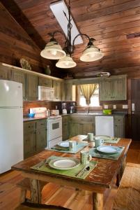 a kitchen with a table and a white refrigerator at The Dogwood Breeze in Aquone