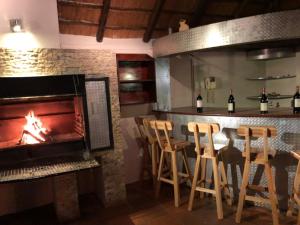 a bar with a fireplace and a table with chairs at Africaren Budget Stay in Kempton Park