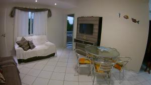 sypialnia z łóżkiem, stołem i telewizorem w obiekcie Apartamento Guaratuba w mieście Guaratuba