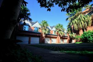 a large house with palm trees in front of it at Spring City Motel in Xinfeng