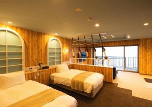 a bedroom with two beds and a balcony at Meijikan in Izu
