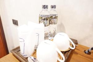 拜縣的住宿－拜縣約卡塔酒店，一张桌子,上面有两瓶白花瓶和苏打水