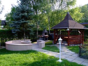 d'un jardin avec un kiosque et un foyer extérieur. dans l'établissement Rajna Apartmanház, à Bogács