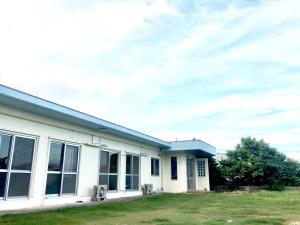 a white building with windows and a cloudy sky at Shimaotoya in Iriomote