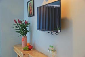 Sapa Aroma Hotel في سابا: طاولة مع زرع الفخار وتلفزيون على الحائط