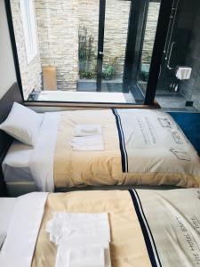 two beds sitting next to each other in a room at Hotel Emit Ueno in Tokyo