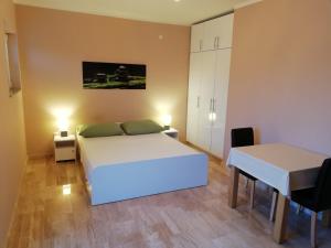 1 dormitorio con cama, mesa y escritorio en Apartmani Karla, en Zablaće
