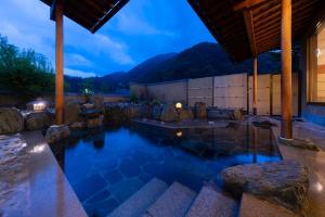 a pool in a house at night with mountains at Otogitei Kofu in Achi