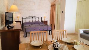 ein Wohnzimmer mit einem Tisch und einem Bett in der Unterkunft Una volta a Martina in Martina Franca