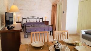 a living room with a table and a bed at Una volta a Martina in Martina Franca
