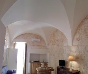 a living room with arched ceilings and a tv at Una volta a Martina in Martina Franca