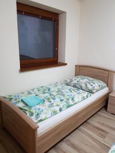 Cama en habitación con ventana en Apartmány Bystrá-Chopok, en Brezno