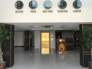 a hallway with clocks on the wall of a building at Apple Hotel Two - Near Phnom Penh Airport in Phnom Penh