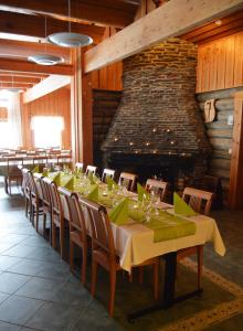 a dining room with a long table and a fireplace at Holiday Village Himmerki in Posio