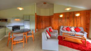 a living room with a couch and a table at Whispering Pines Cottages in Burnt Pine