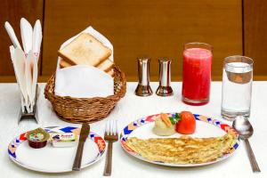 a table with a plate of food and a basket of bread at Ramoji Greens Inn in Pedda Ambarpet