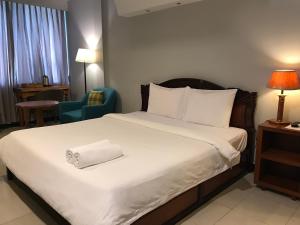 Una habitación de hotel con una cama con una toalla. en DoDo Guesthouse, en Phnom Penh