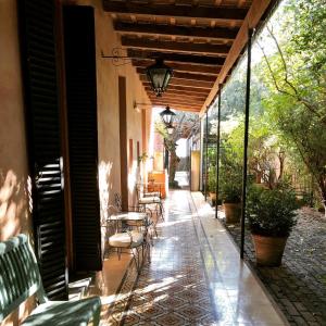 a patio with chairs and tables on a building at Antigua Casona Bed & Breakfast in San Antonio de Areco