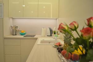 a kitchen with a sink and a counter with flowers at Piękny Apartament - Darłówko Wschodnie in Darłówko