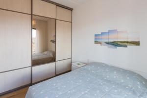 1 dormitorio con cama y espejo en Cosy city apartment en Pärnu