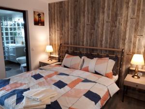 a bedroom with a bed with a wooden wall at Casa Mea in Eforie Nord +43 photos