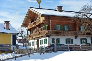 ゴイング・アム・ヴィルデン・カイザーにあるGassenhofの雪の中にバルコニーが付いた木造家屋