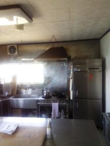 a kitchen with a sink and a stainless steel refrigerator at Minshuku Kamagari in Kure
