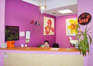 a man sitting at a counter in a pink room at City Center Hostel in Kyiv