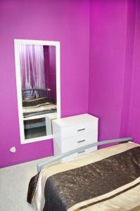 ein rosafarbenes Zimmer mit einem Bett und einem Spiegel in der Unterkunft City Center Hostel in Kiew
