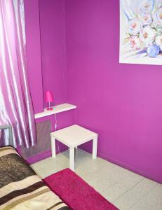 ein rosafarbenes Zimmer mit einem weißen Tisch und einer rosa Wand in der Unterkunft City Center Hostel in Kiew
