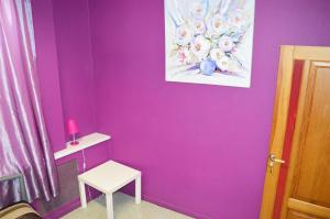 ein lila Zimmer mit einem Tisch und einem Stuhl in der Unterkunft City Center Hostel in Kiew
