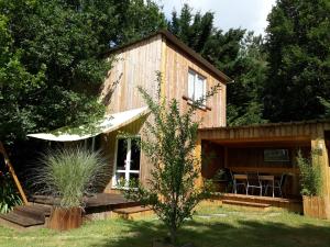 eine Blockhütte mit einem Tisch und Stühlen im Hof in der Unterkunft Gîte de la Rotterie in Saint-Mars-dʼOutillé