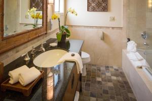 a bathroom with a tub, sink, and mirror at Tradewinds Carmel in Carmel