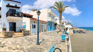 una calle junto a una playa con una palmera y edificios en Myrtos Mare Suites, en Myrtos