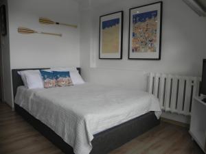 um quarto com uma cama com duas fotografias na parede em Apartamenty Starówka em Colberga