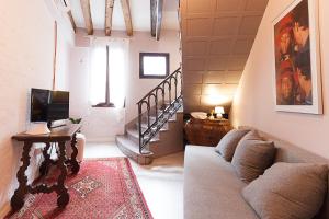 ein Wohnzimmer mit einem Sofa, einem Tisch und einer Treppe in der Unterkunft Ca' della scala in Venedig