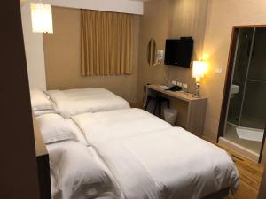 a hotel room with two beds and a television at The Riverside Hotel Hengchun in Hengchun
