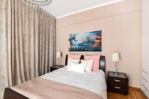 a bedroom with a bed with pink and white pillows at Acropolis Stylish Suite in Athens