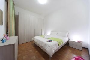 a bedroom with a white bed with a green blanket at Hotel del Mar in Sottomarina