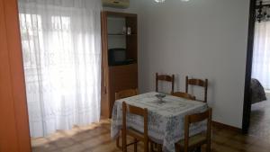 une salle à manger avec une table, des chaises et une télévision dans l'établissement Casa Salvaggio, à Grotte