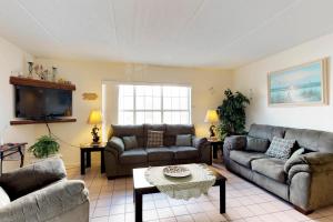 a living room with two couches and a table at Fiesta Sol Condominiums in South Padre Island