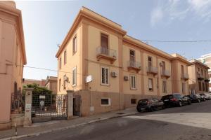 a building with cars parked on the side of a street at Talia B&B Guest House in Reggio Calabria