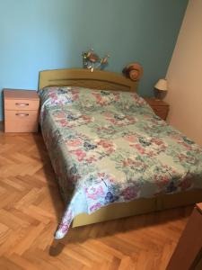 un letto con piumone floreale in una camera da letto di Apartment Jasna B a Omišalj (Castelmuschio)