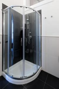 y baño con ducha y mampara de cristal. en Talia B&B Guest House, en Reggio Calabria