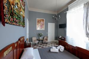 1 dormitorio con 1 cama y 1 mesa con sillas en Talia B&B Guest House, en Reggio Calabria