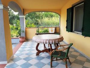 een tafel en stoel op een patio met een raam bij Villetta Su Barrali in Orosei