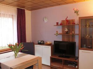 a living room with a tv and a table at Cosy Bungalow in Alt Bukow OT Bantow with Terrace in Bantow