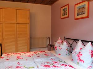 a bedroom with a bed with pink flowers on it at Cosy Bungalow in Alt Bukow OT Bantow with Terrace in Bantow