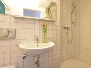 een badkamer met een wastafel en een vaas met bloemen bij Wohnung in Wismar mit Garten in Wismar +32 foto's