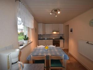 a kitchen with a blue table and chairs in a room at Wonderful Apartment in Elpe with Garden in Kröpelin